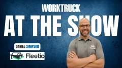 Man standing with arms crossed in front of blue background with Work Truck logo and At The Show in large white letters, plus a Fleetio logo.
