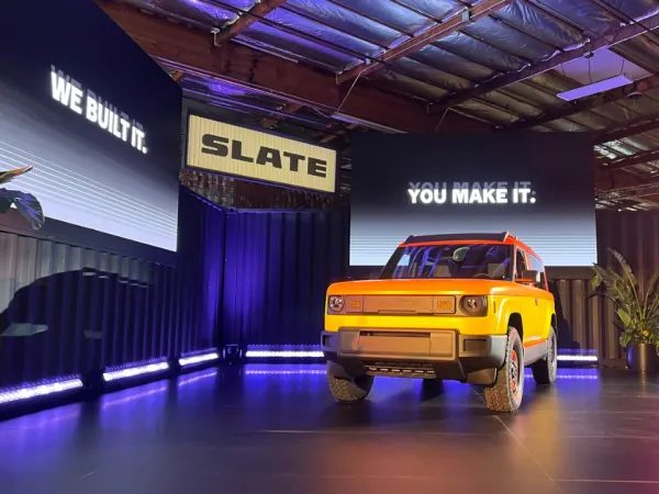 A yellow Slate pickup truck on a round center stage at Slate design center.