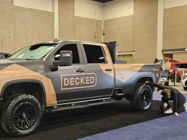 A brown and black pickup truck with DECKED logo