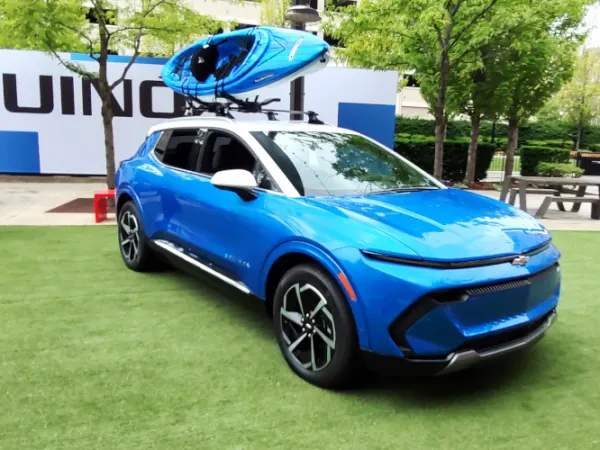 Blue compact SUV with white roof and a blue and white kayak on a roof rack.