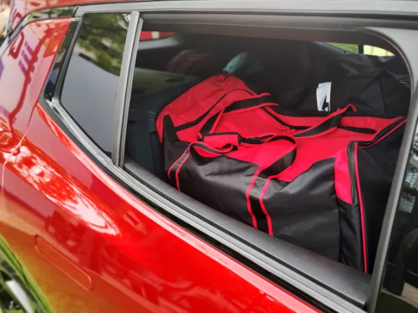 View in through passenger rear window showing red and black backs in the cargo area with seats folded down.