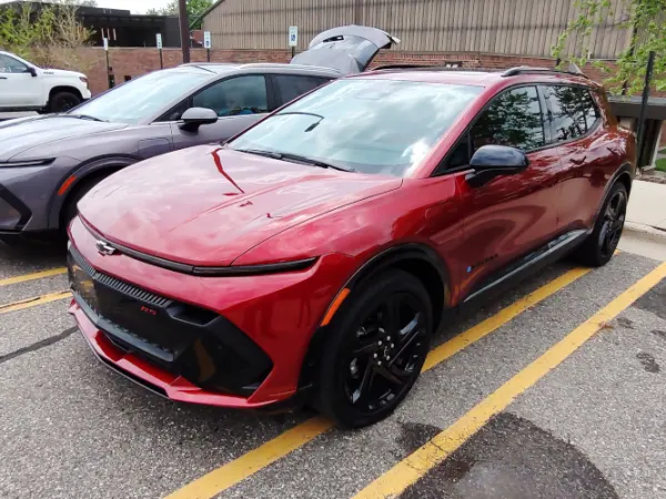 Two small SUVs, one red and one gray, parked in a lot.