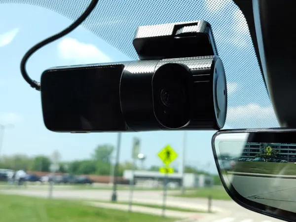 Dashcam shown mounted on the windshield to the left of the rearview mirror.