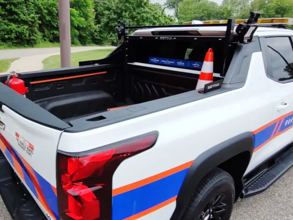 View into the bed of a white work truck with logos and paint marking indicating Road Commission.