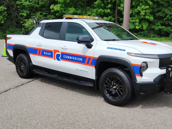 White work truck with red and blue markings for Road Commission.