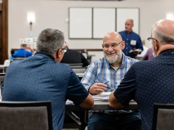 Attendees leaning in and exchanging ideas during a one-on-one Work Truck Exchange meeting.