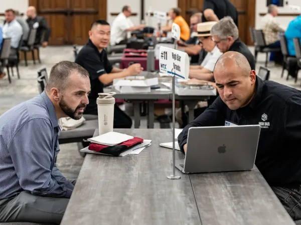 Two attendees reviewing details on a laptop during a focused Work Truck Exchange session.