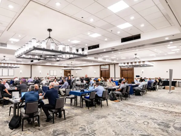 Wide view of Work Truck Exchange with dozens of attendees engaged in meetings.