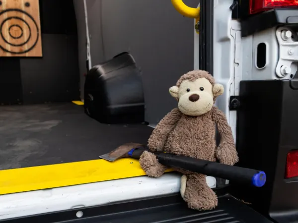 Stuffed monkey sitting with an axe inside the Legend Fleet axe-throwing van at Work Truck Exchange 2025.