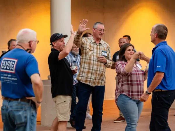 Work Truck Exchange 2025 attendees celebrate with high fives at the Legend Fleet axe-throwing ban.