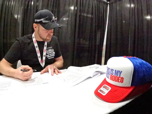 Young man taking a test on paper at a table.