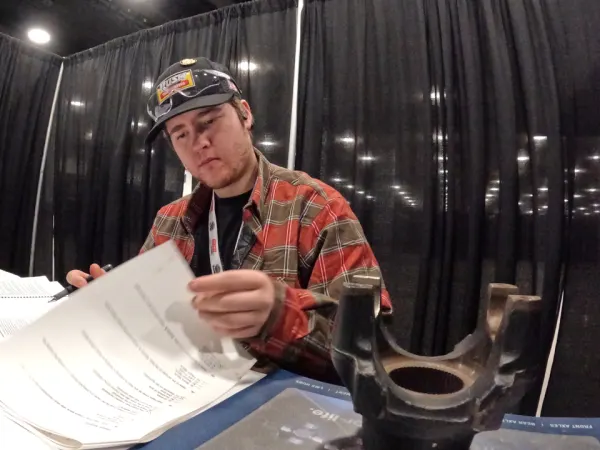 Young man studying paperwork at a table.