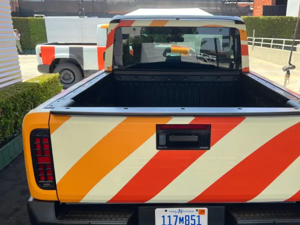 A rear view of the pickup truck including the flat bed and the cab.