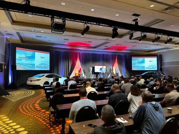 Wide shot of crowd in large hotel conference room. 