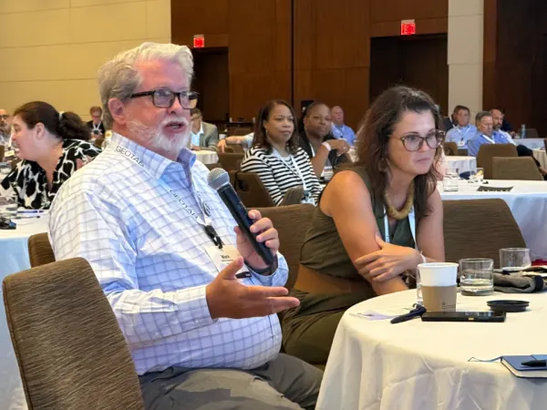 Man in audience asks question to panelists.