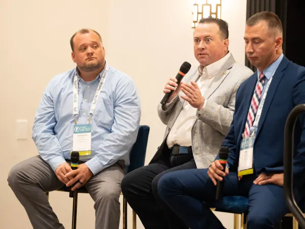 Man with microphone during panel seminar. 