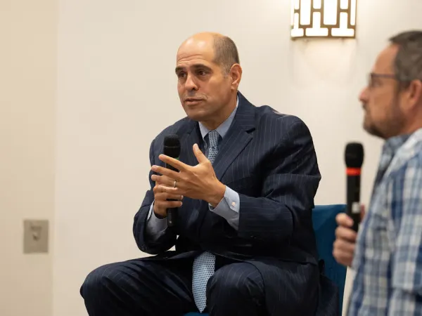Two men conversing during presentation. 