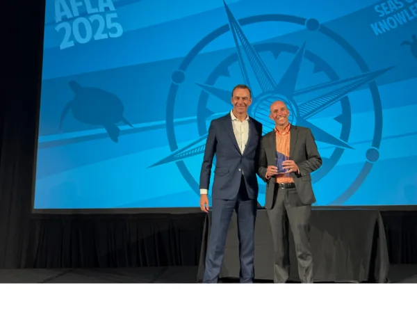 Two men pose for photo after award is given out.