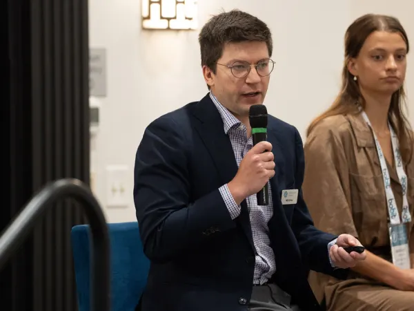 Man with microphone during panel seminar. 