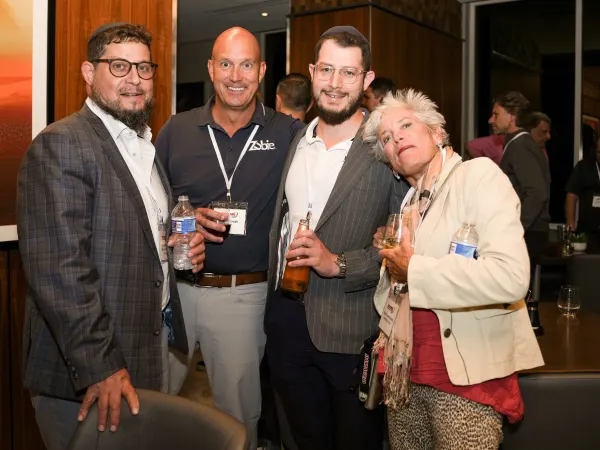 four gather for photo at cocktail party