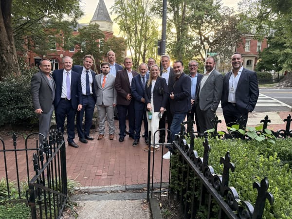Group gathers for a photo outside brownstone