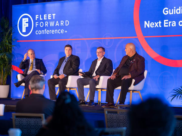 Four men sit on stage at FFC2026 with a blue background
