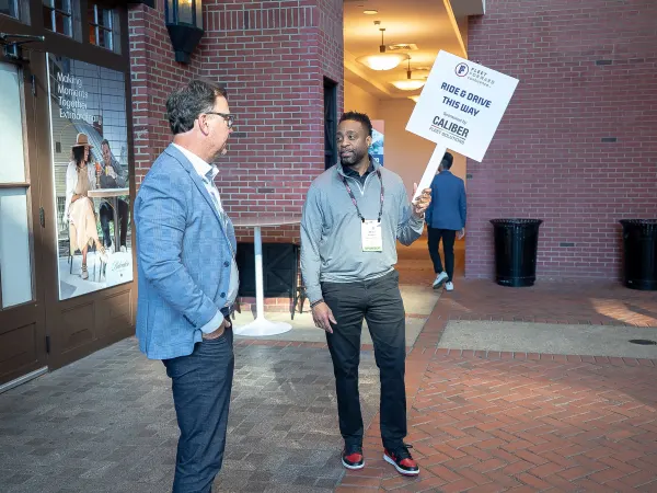 A man at FFC2026 holds a sign in his right hand 