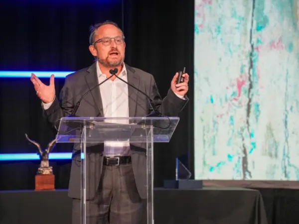 Man making speech on stage.