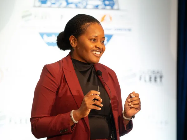 Woman delivers presentation on stage. 