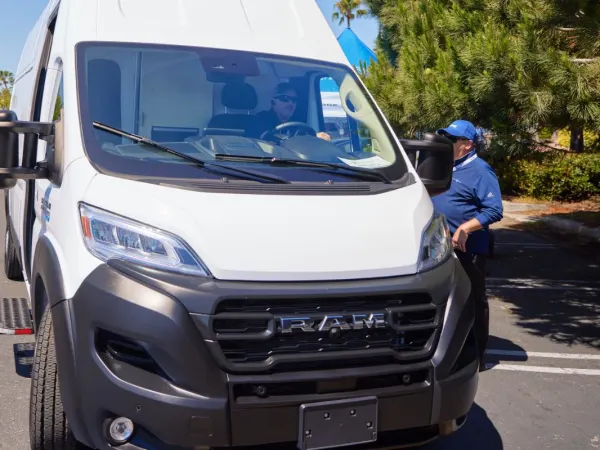 Man looks inside cargo van. 