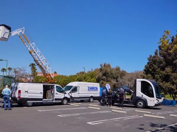 Three commercial vehicles in parking lot. 