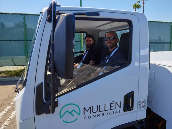 An event attendee drives an electric truck. 
