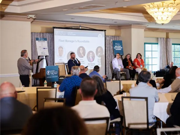 Four panelists deliver a seminar in a hotel conference room. 