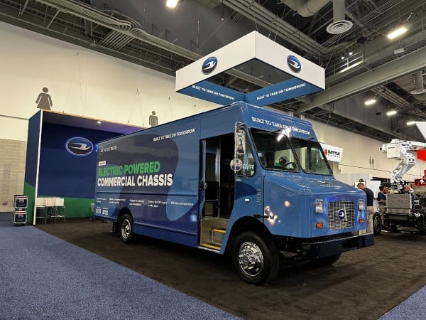 A step van sits on a trade show floor. 
