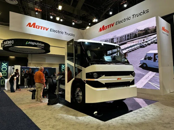 A new large electric truck sits in a show floor display. 