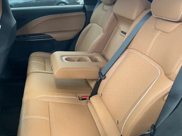 Left side view of two rear passenger seats separated by armrest with cupholders.