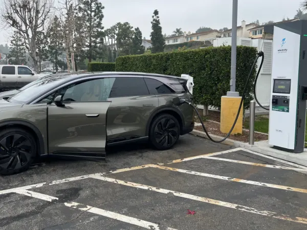 Lucid Gravity backed up against an EV charging station.