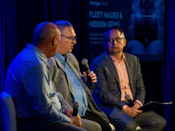 Three panelists on stage during seminar.