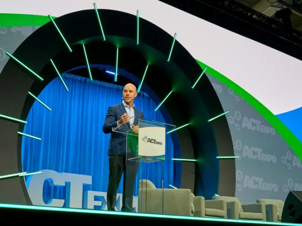 Man onstage delivering a keynote address.