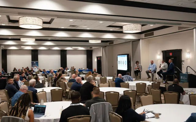Wide shot of hotel conference room during a presentation. 