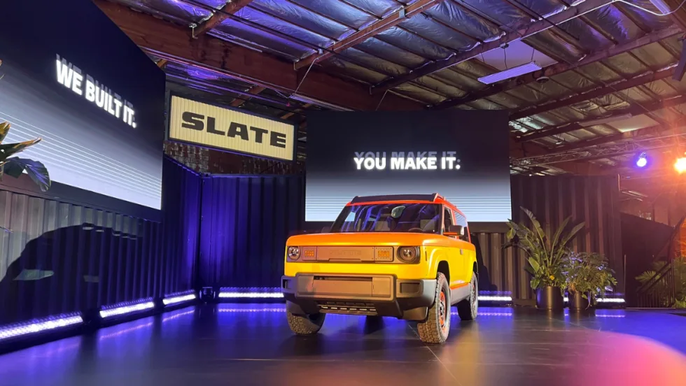 Yellow Slate pickup truck on a platform.