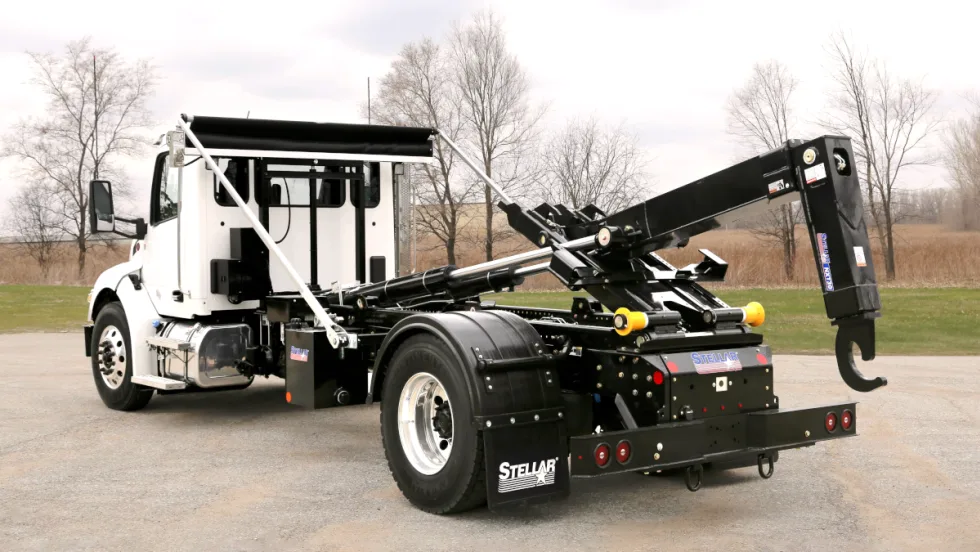 White cab hooklift truck parked facing away from the camera.