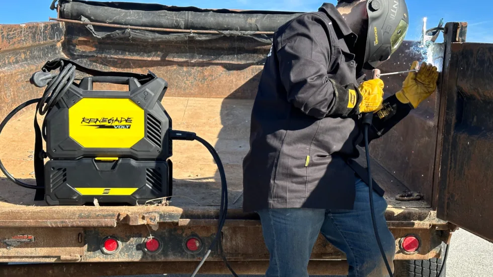 Man welding with the welding unit in the back of a work truck.