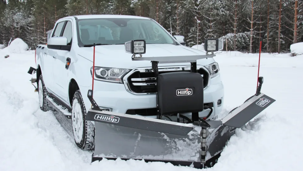 White truck with attached snow plow, ideal for winter maintenance.