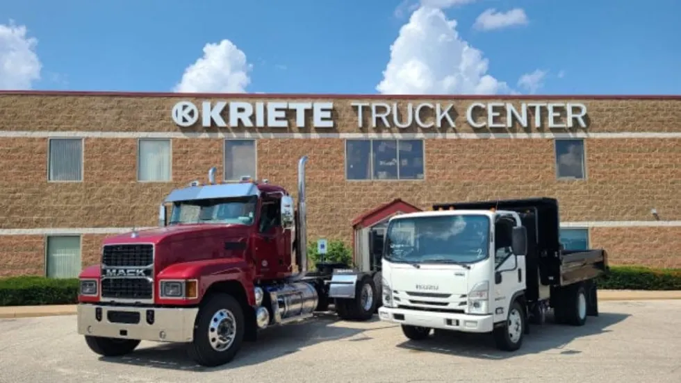 Two trucks parked in front of an industrial building.