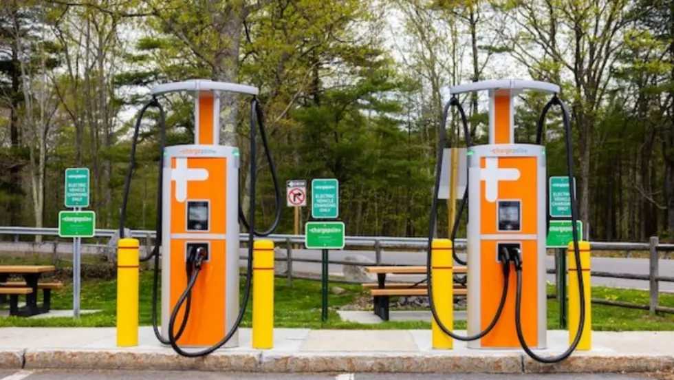 Two electric charging stations with orange and white signs.