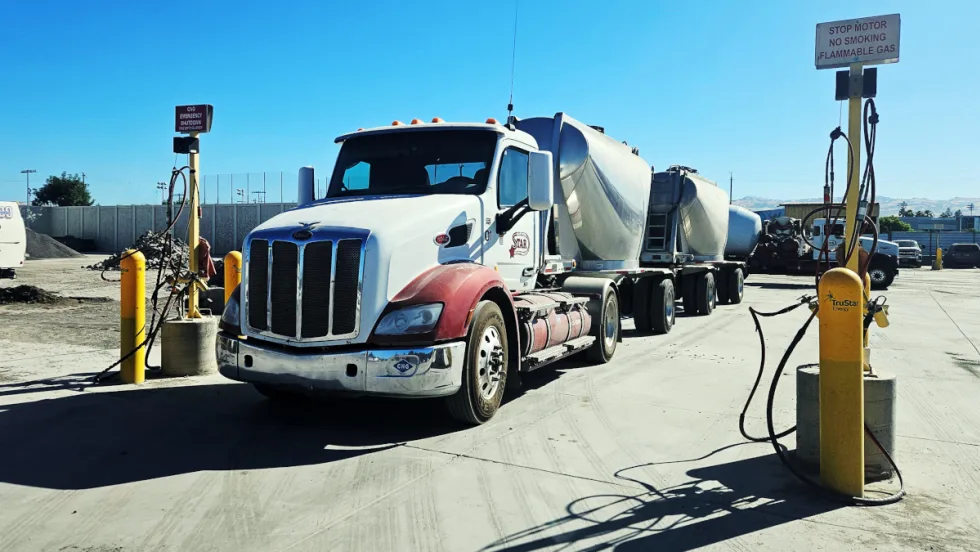 Truck parked with two bulk haul trailers behind it.