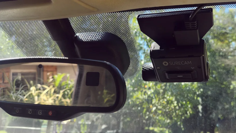 Photo of a dashcam mounted next to a rearview mirror. 