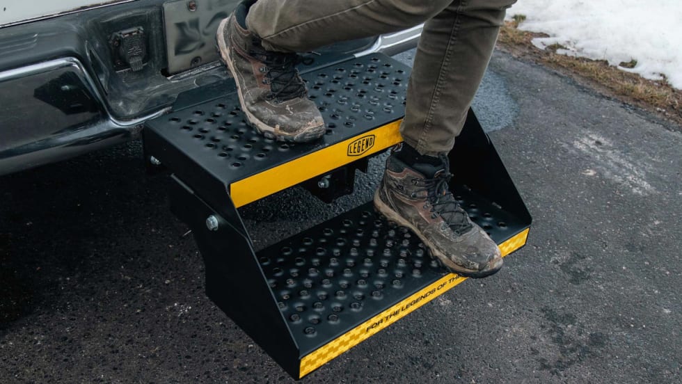 Person exiting the bed of a truck using a two-step platform installed in the receiver.