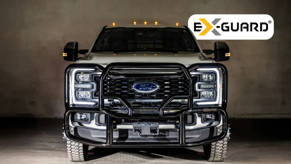 Front view of a Ford Heavy Duty pickup with a black grille guard and logo for Ex-Guard.